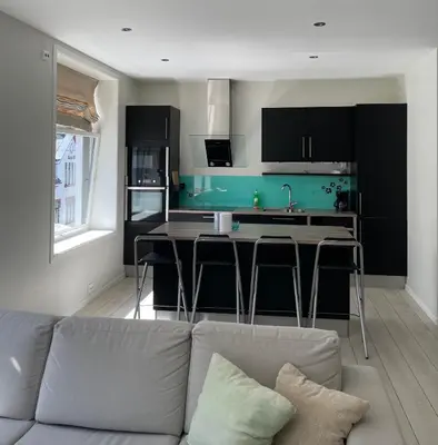 a living room with a couch and a kitchen at City Center Apartment in Ålesund