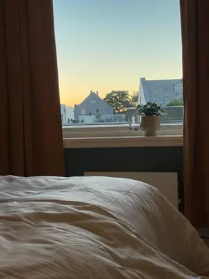 a bedroom with a bed and a window with a view at City Center Apartment in Ålesund