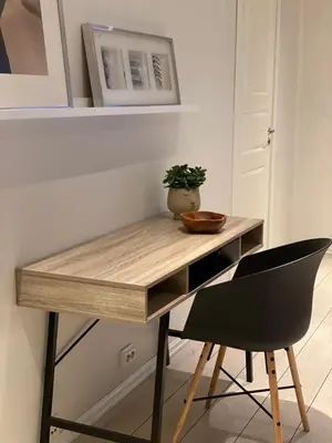 a wooden desk with a chair in a room at City Center Apartment in Ålesund