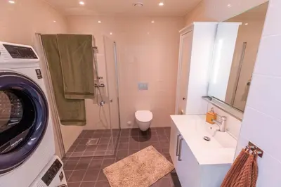 a bathroom with a washing machine and a washer at Mjøssuite with lovely view in Ringsaker