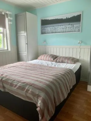 a bedroom with a bed with a striped blanket at Exclusive fjordside villa with swimming pool, sauna, jacuzzi and boat hire in Sveio