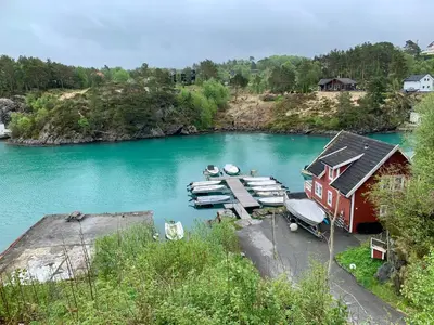 an aerial view of a river with boats and a house at Exclusive fjordside villa with swimming pool, sauna, jacuzzi and boat hire in Sveio