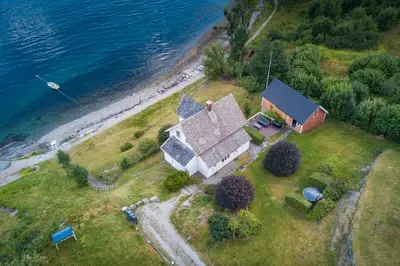 an aerial view of a house next to the water at Feriehus med badestamp in Lavik