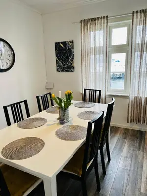 a dining room with a white table and chairs at Feriehus med badestamp in Lavik