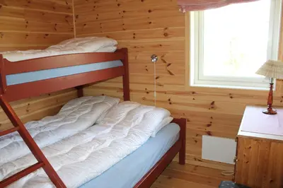 a bedroom with a bunk bed in a log cabin at Storemyr by Norgesbooking - cabin with amazing view in Hol