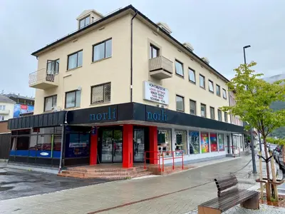 a building on a street with a bench in front of it at Åndalsnes Sentrum 1-room Apartment in Åndalsnes