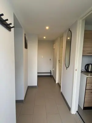 a hallway in a apartment with white walls at Sukkertoppen Apartment in Ålesund