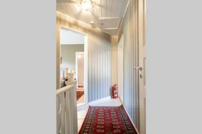 a hallway with a red rug next to a door at Eika Cottage: Cozy, rural, spacious and well-equiped in Åmot