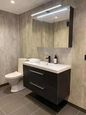 a bathroom with a sink and a toilet and a mirror at Olden Studioapartment in Olden