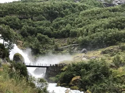 a bridge over a river with a waterfall at Olden Studioapartment in Olden