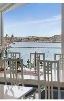 a table and chairs with a view of the water at Atlantic Panorama in Vevang