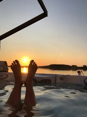 a person laying in a bath tub with their feet in the water at Atlantic Panorama in Vevang