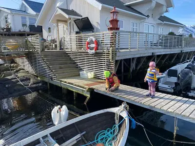 two children standing on a dock next to a boat at Atlantic Panorama in Vevang