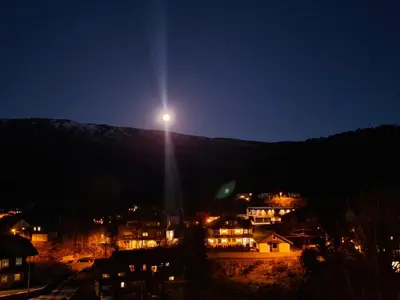 a light on top of a mountain at night at Nature View Apartment in Espeland in Bergen