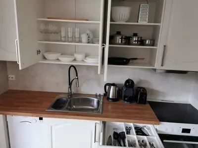 a kitchen with a sink and white cabinets at Nature View Apartment in Espeland in Bergen