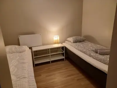 a room with two beds and a table with a lamp at Nature View Apartment in Espeland in Bergen