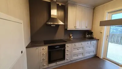 a kitchen with white cabinets and a stove top oven at Hjartdal Fjellstoge & Storhytte in Hjartdal