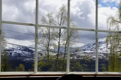 a view of a snow covered mountain through a window at Hjartdal Fjellstoge & Storhytte in Hjartdal