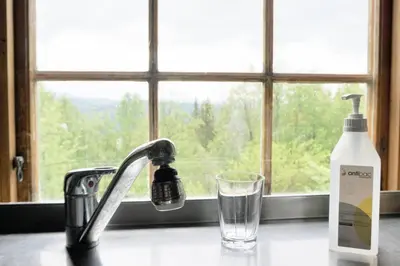 a sink with a glass and a bottle of soap and a window at Hjartdal Fjellstoge & Storhytte in Hjartdal