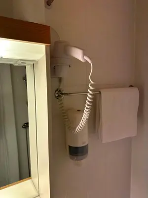 a hairdryer hanging on a wall in a bathroom at Hotel Videseter in Stryn