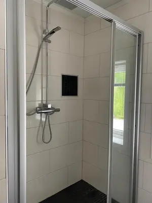 a shower with a glass door in a bathroom at Indreli feriehus in Flåm