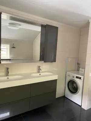 a bathroom with two sinks and a washing machine at Indreli feriehus in Flåm