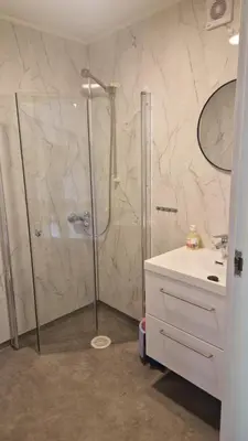 a bathroom with a shower and a white sink at Kvamsdal Pensjonat 2 in Eidfjord