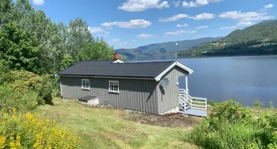 a small building on the side of a lake at Halsteinsplassen in Surteberg