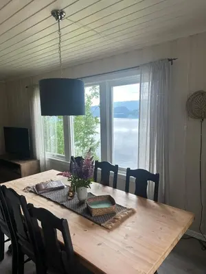 a dining room table with a view of the ocean at Halsteinsplassen in Surteberg