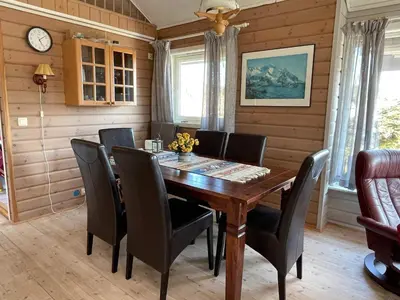 a dining room with a wooden table and chairs at 6 person holiday home in Espevær-By Traum in Espevær
