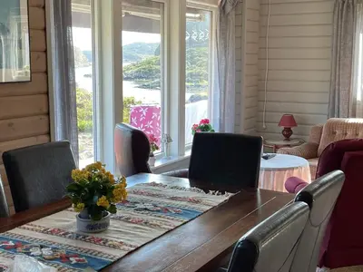 a dining room with a table and chairs and a window at 6 person holiday home in Espevær-By Traum in Espevær