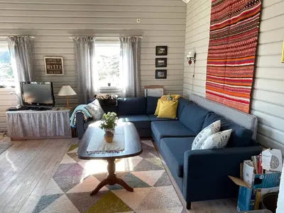 a living room with a blue couch and a table at 6 person holiday home in Espevær-By Traum in Espevær