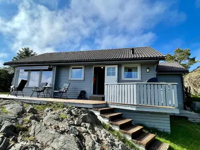a small blue house with a porch and stairs at 6 person holiday home in Espevær-By Traum in Espevær