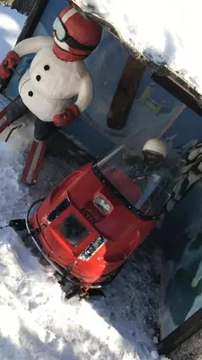 a toy snowman standing next to a red car in the snow at In the middle of Trysil fjellet - Welcome Center - Apartment with 4 bedrooms and sauna - By bike arena and ski lift in Trysil