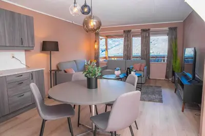 a kitchen and living room with a table and chairs at Vestly in Etnesjøen