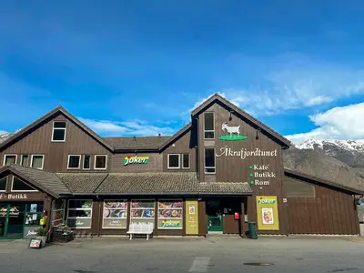 a store front of a building with mountains in the background at Vestly in Etnesjøen