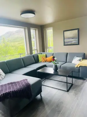 a living room with a blue couch and a table at Fosskamben 1 Moderne hytte ikkje langt frå Sogndal in Sogndal