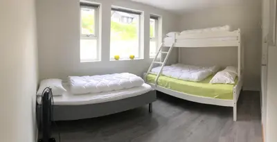 two bunk beds in a room with two windows at Fosskamben 1 Moderne hytte ikkje langt frå Sogndal in Sogndal