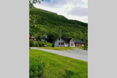 a house on the side of a road with a mountain at Casa Kleiv i Sogndalsdalen in Sogndal
