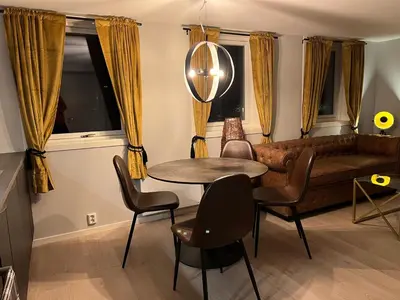 a living room with a couch and a table and chairs at Atlantic Panorama Villa Kalle in Kristiansund