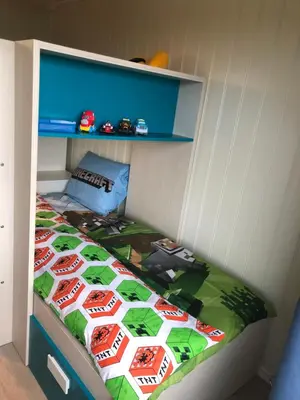 a bed in a childs bedroom with a race car quilt at Atlantic Panorama Villa Kalle in Kristiansund