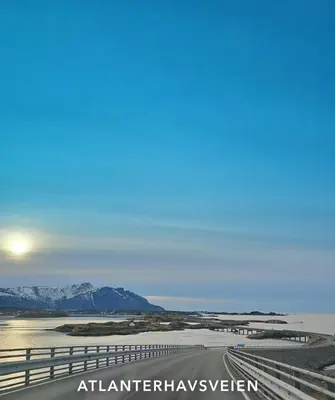 a road in the desert with mountains in the background at Rødseth gårdsovernatting Hytter in Molde