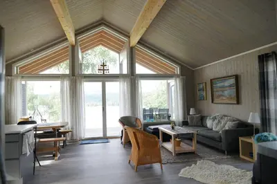 a living room with a couch and a large window at Luxury Norwegian Cottage in Hurdal