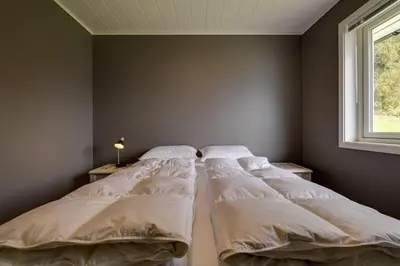 two beds in a bedroom with a window at Flotunet - Jørnhuset in Stryn
