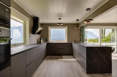 a kitchen with a large island and windows at Flotunet - Jørnhuset in Stryn