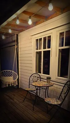 a patio with two chairs and a table on a porch at Between Fjord og Glacier in Ålfoten