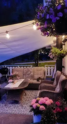 a patio with couches and a table and flowers at Between Fjord og Glacier in Ålfoten
