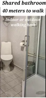 a bathroom with a toilet and a shower with the words shared bathroom meters to at Rødseth Gårdsovernatting Familierom in Molde