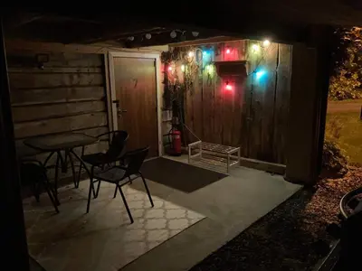 a patio with a table and chairs at night at Rødseth Gårdsovernatting Familierom in Molde