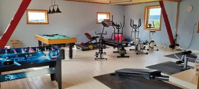 a gym with exercise equipment and a pool table at Rødseth Gårdsovernatting Familierom in Molde
